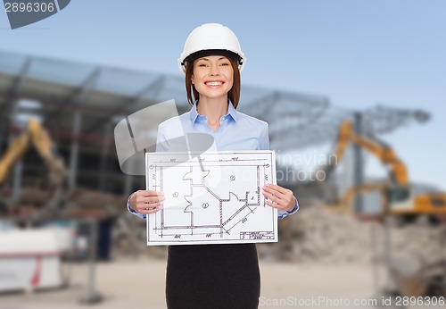 Image of businesswoman in white helmet with blueprint
