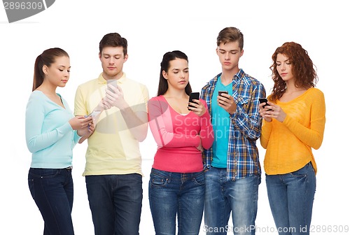 Image of group of serious teenagers with smartphones