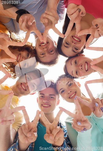 Image of group of smiling teenagers showing victory sign