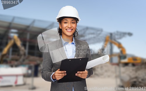 Image of smiling architect in helmet with blueprint