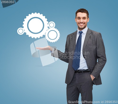 Image of smiling businessman holding settings icon