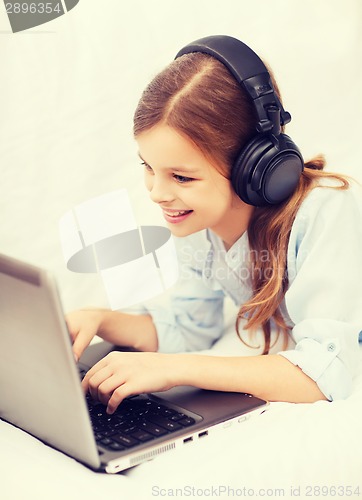 Image of girl with laptop computer and headphones at home