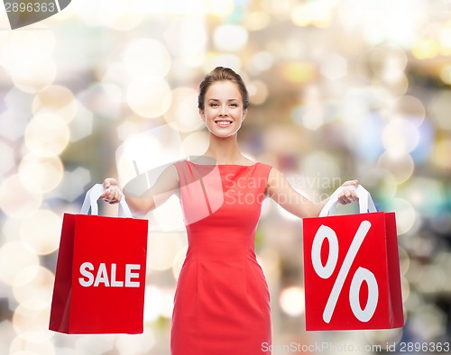Image of young woman in red dress with shopping bags