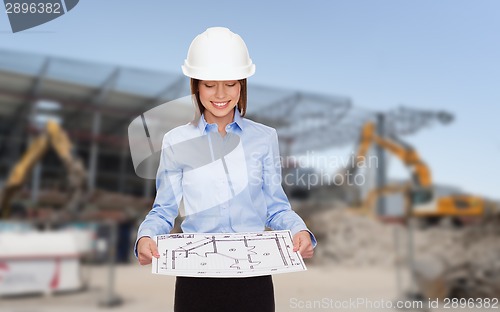 Image of businesswoman in white helmet with blueprint