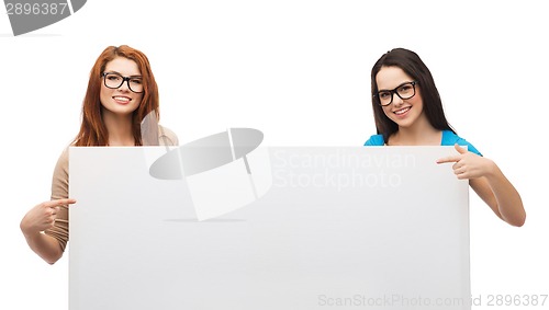 Image of two smiling girls with eyeglasses and blank board