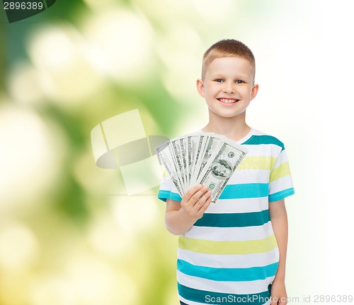 Image of smiling boy holding dollar cash money in his hand