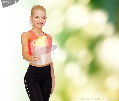 Image of smiling sporty woman with protein shake bottle