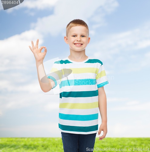 Image of little boy in casual clothes making OK gesture