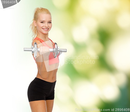 Image of young sporty woman with heavy steel dumbbell