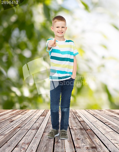 Image of smiling little boy pointing finger at you