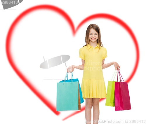 Image of smiling little girl in dress with shopping bags