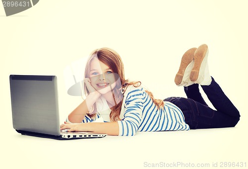 Image of smiling student girl with laptop computer lying