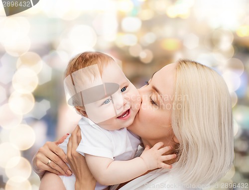 Image of happy mother kissing smiling baby
