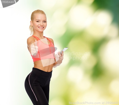 Image of smiling sporty woman with smartphone