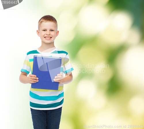 Image of smiling little student boy with blue book