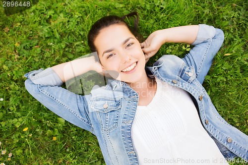 Image of smiling young girl lying on grass