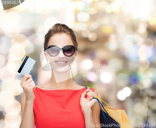 Image of smiling woman with shopping bags and plastic card