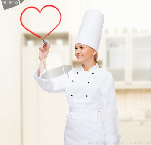 Image of smiling female chef writing something on air