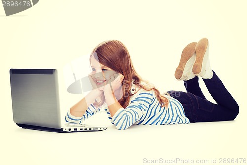 Image of smiling student girl with laptop computer lying