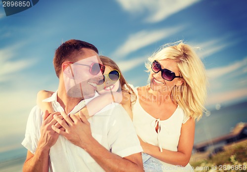 Image of happy family in sunglasses having fun outdoors