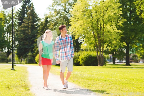 Image of smiling couple walking in park