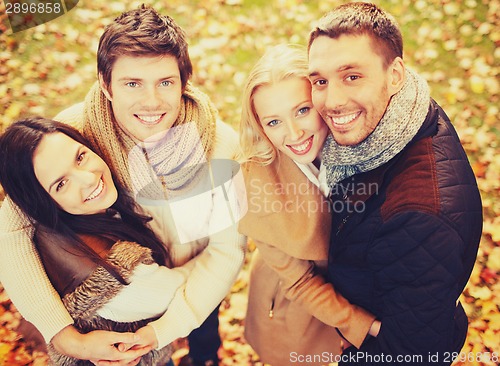 Image of group of friends having fun in autumn park