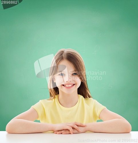 Image of beautiful little girl sitting at table