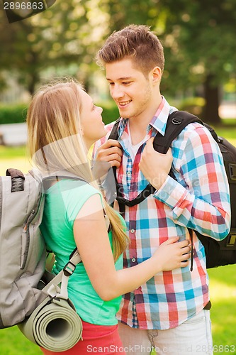 Image of smiling couple with backpacks in nature