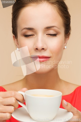 Image of smiling woman in red dress with cup of coffee