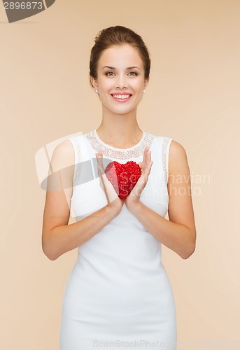 Image of smiling woman in white dress with red heart