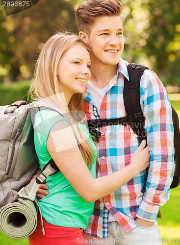 Image of smiling couple with backpacks in nature
