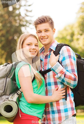 Image of smiling couple with backpacks in nature
