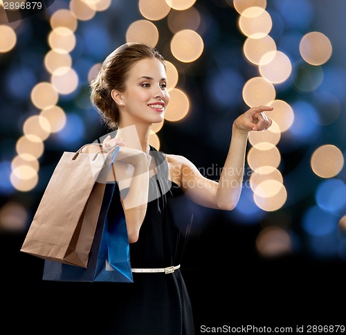 Image of smiling woman in dress with shopping bags