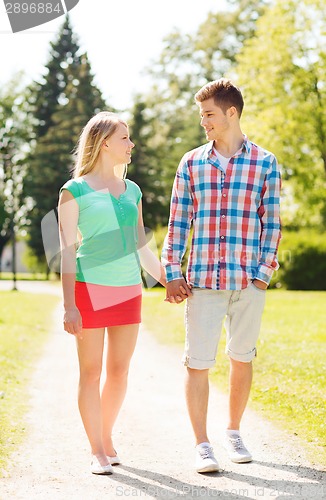 Image of smiling couple walking in park