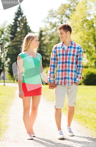 Image of smiling couple walking in park