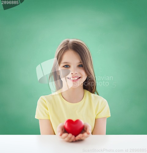 Image of beautiful little girl sitting at table