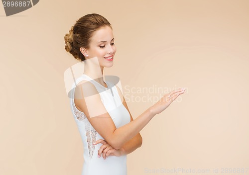 Image of smiling woman in white dress with diamond ring