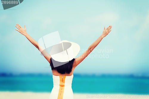 Image of girl with hands up on the beach