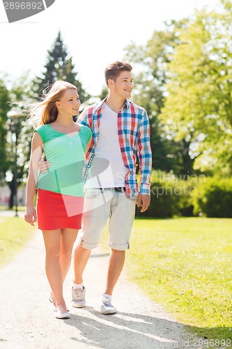 Image of smiling couple walking in park