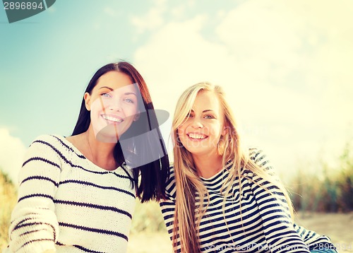 Image of smiling girlfriends having fun on the beach