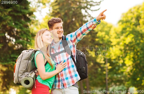 Image of smiling couple with backpacks in nature