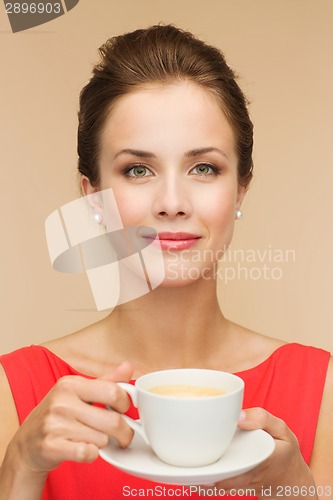 Image of smiling woman in red dress with cup of coffee