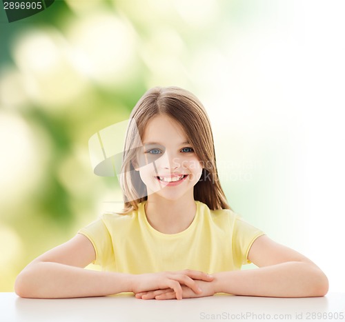 Image of beautiful little girl sitting at table