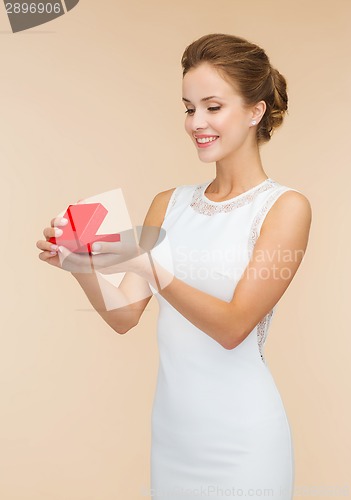 Image of smiling woman holding red gift box