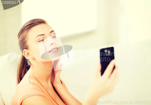 Image of woman making self portrait with smartphone