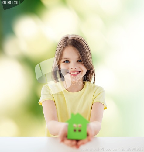 Image of beautiful little girl holding paper house cutout