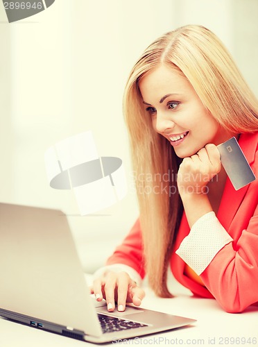 Image of businesswoman with laptop using credit card