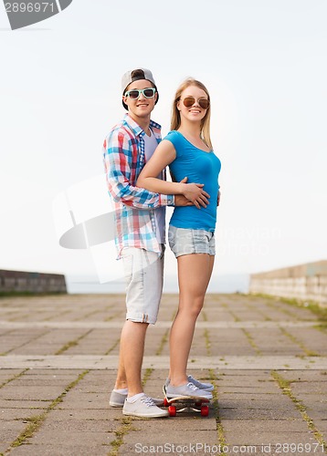 Image of smiling couple with skateboard outdoors