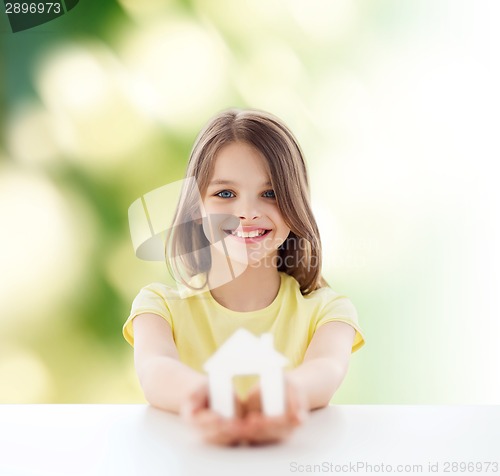 Image of beautiful little girl holding paper house cutout