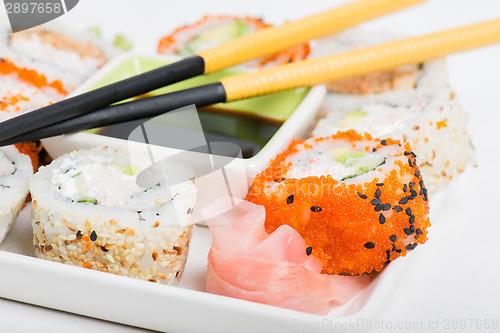 Image of Soy sauce, chopsticks and sushi mix